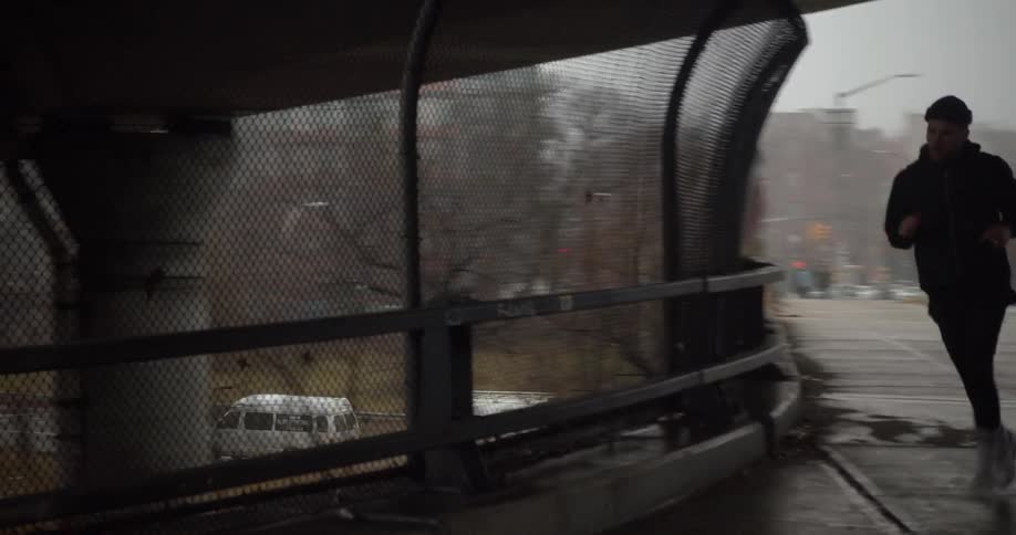 A man jogs on an overpass in the city