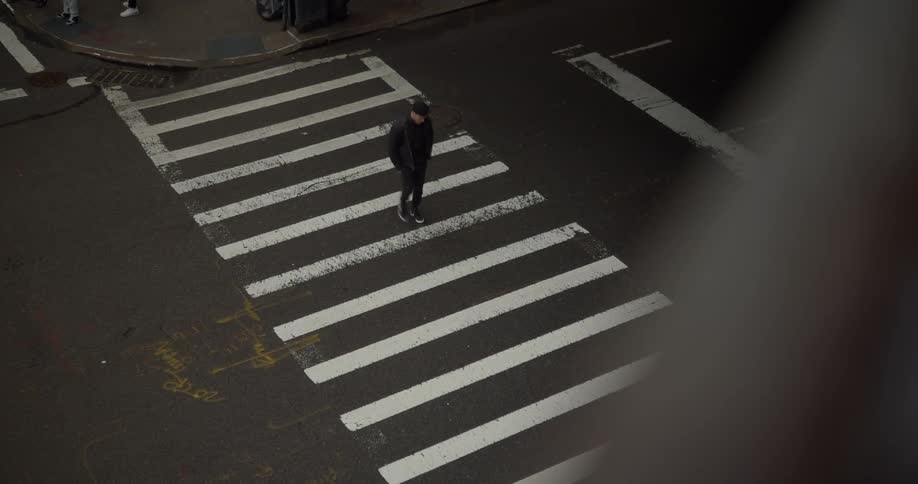 A man walks across a street at a crosswalk