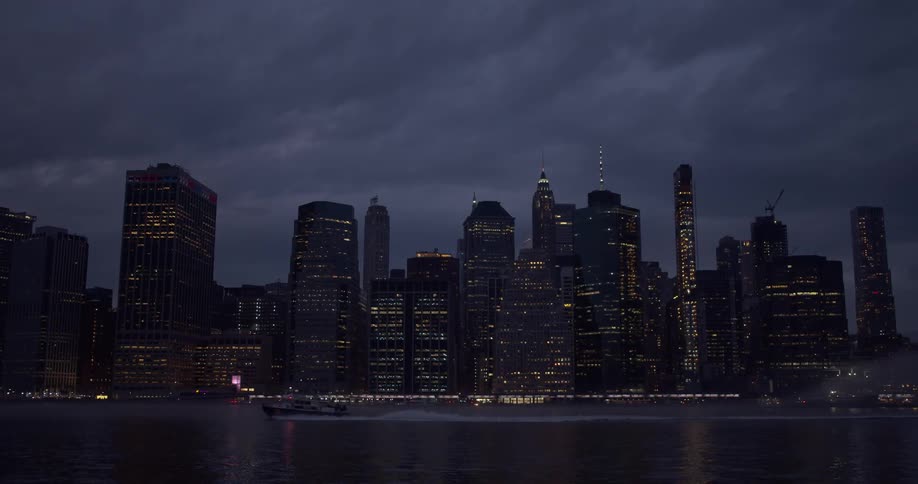 A boat traveling on a river with the city skyline in the background