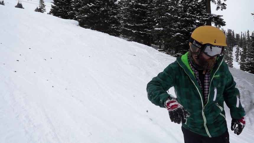 A man snowboards down a snow covered slope