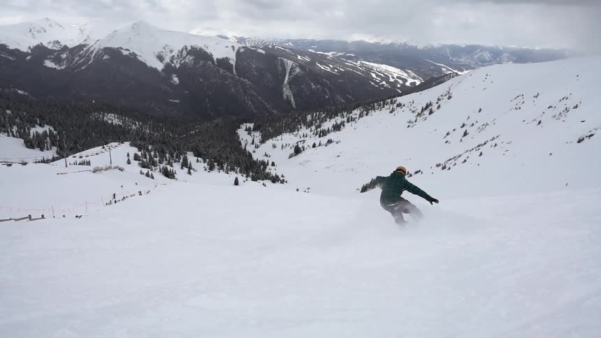 A snowboarder descends a mountain