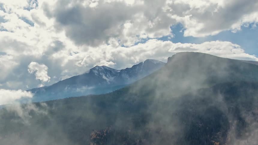 Fog and clouds over a forested mountain