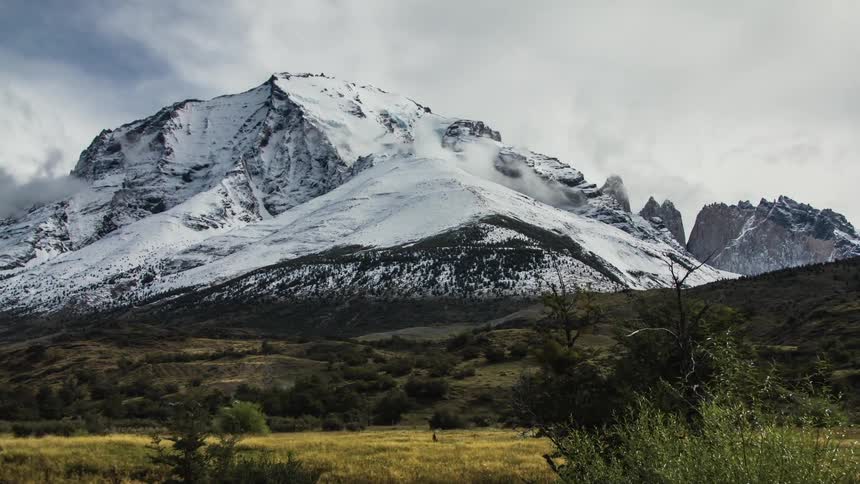 Time lapse of a mountain covered in snow on a cloudy day