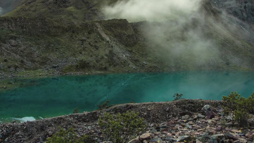 Clouds float and dissipate over a lake