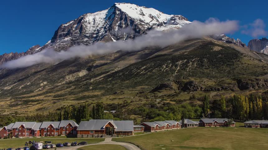 Clouds forming over a mountain behind a village