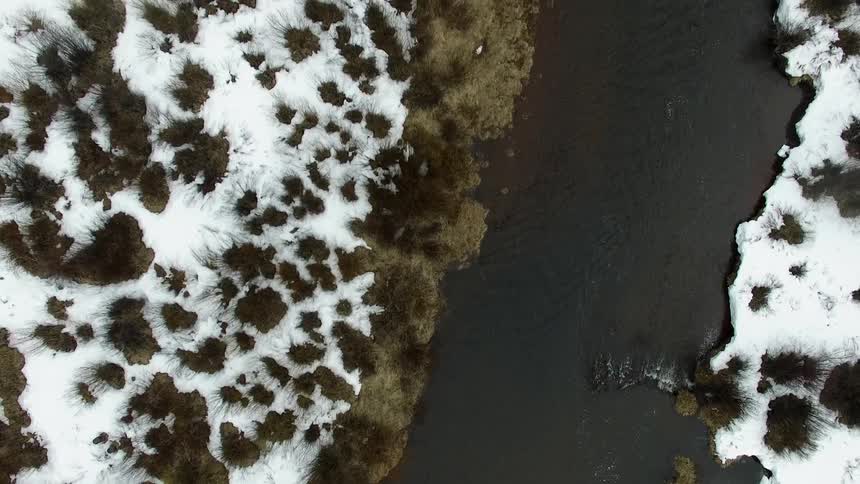 A river flows through a snowy area