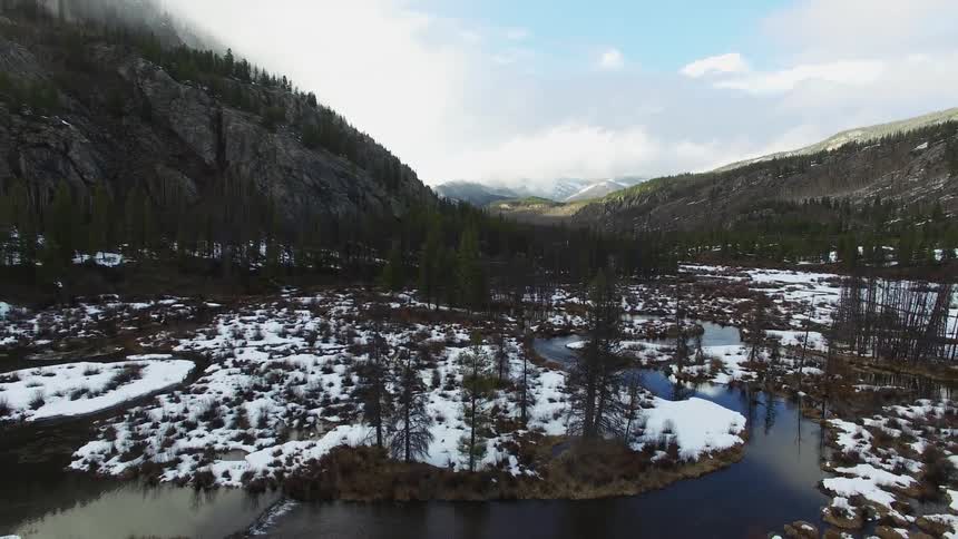 A river cutting through a snowy valley