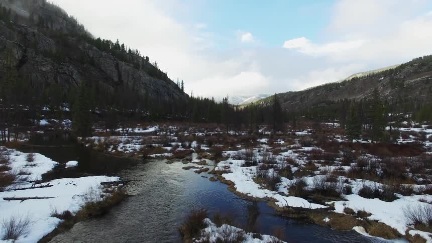 A river cutting through a snow covered area