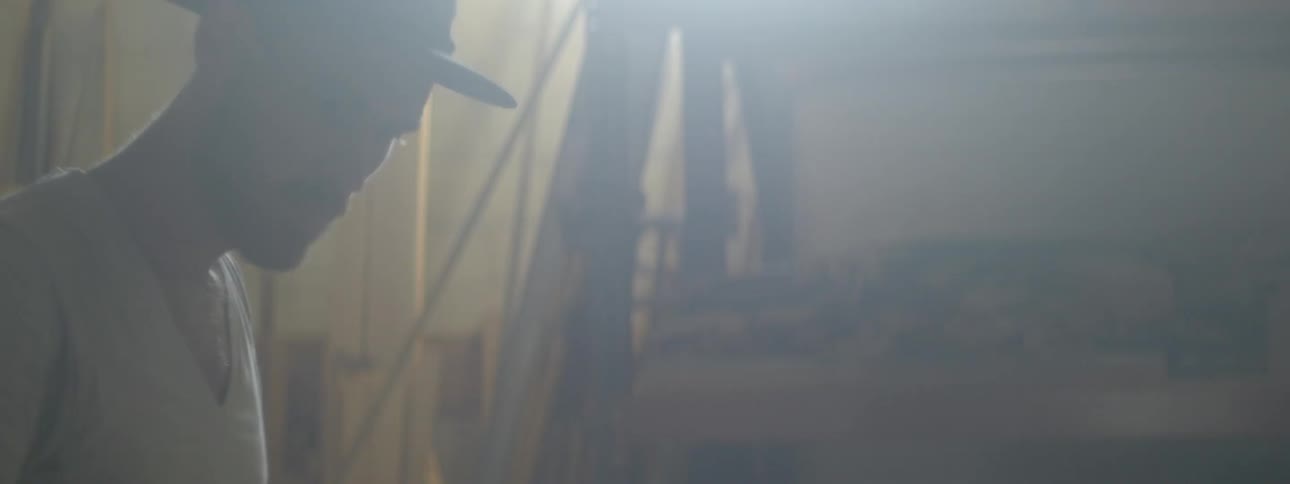 A man sanding a piece of wood in a workshop