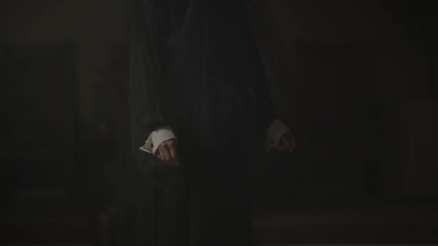 A person in a black dress sways