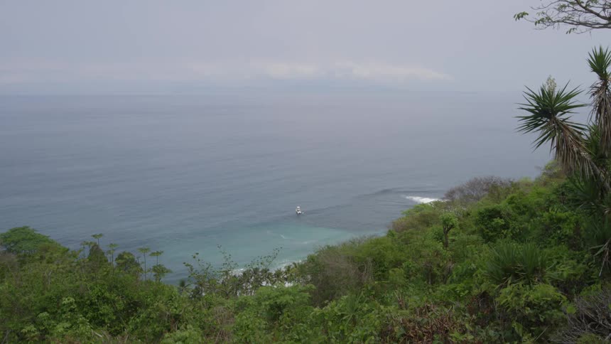 A boat is in the ocean near the coast