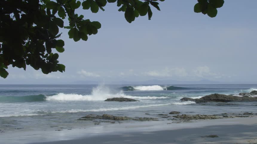 The waves crash on the shore of the beach