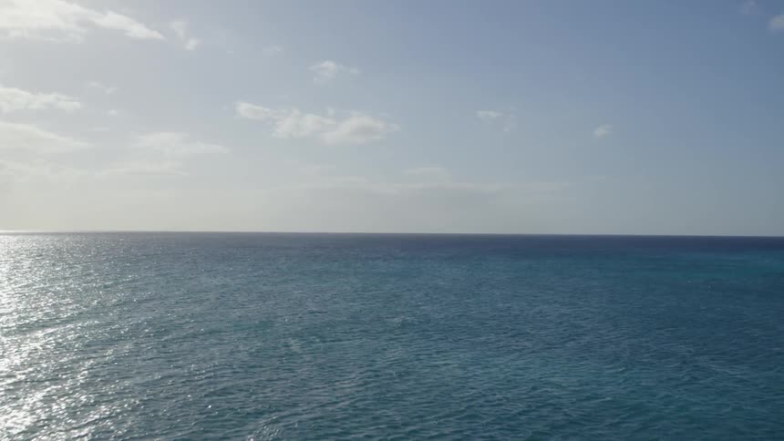 Calm blue tropical waters under a sunny sky