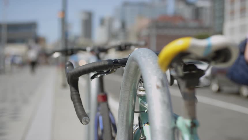 Bicycle locked onto bike rack on sidewalk in town