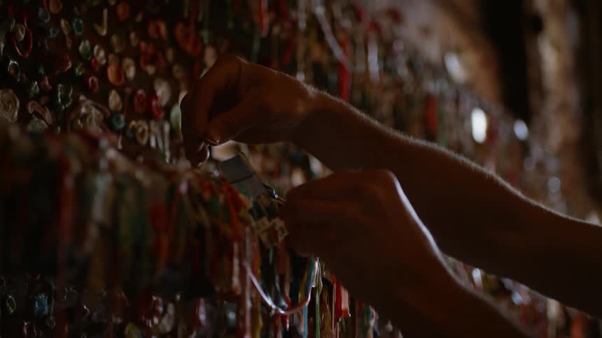 A person places a bracelet on a jewelry display in a store