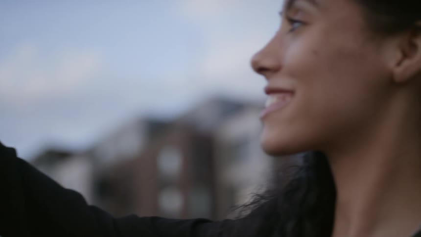 A woman takes a selfie while standing outside in a city
