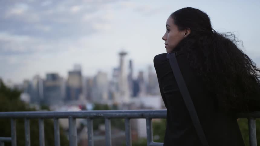 A woman is looking at a downtown skyline