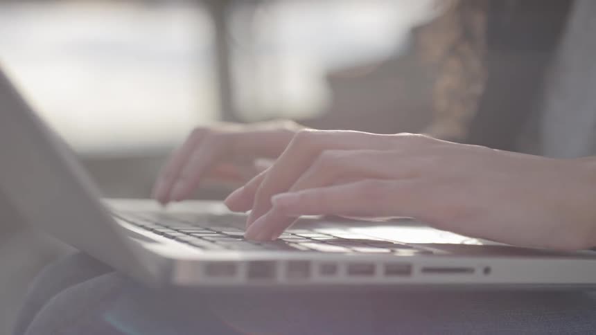 Female hands typing on a laptop keyboard