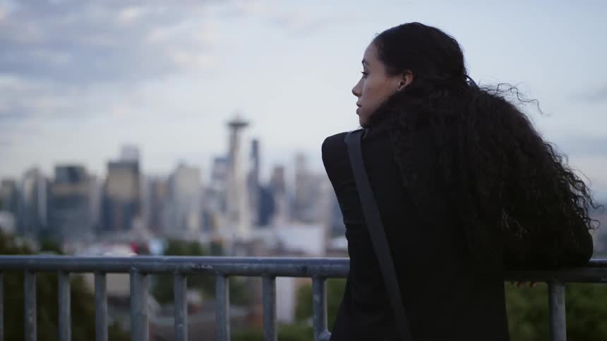 A woman is looking at a downtown skyline