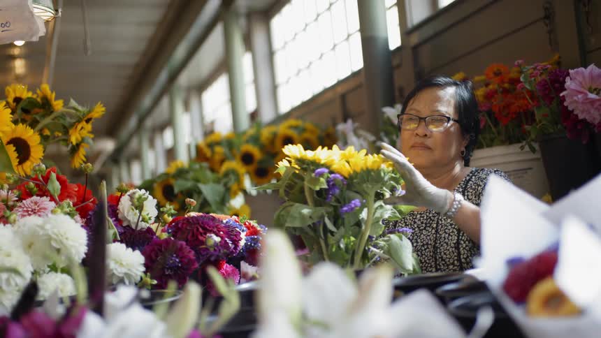 An old man taking care a yellow flower arrangement
