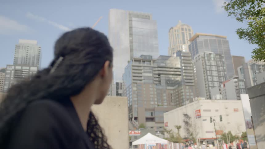 A young woman contemplatively thinking in the middle of city