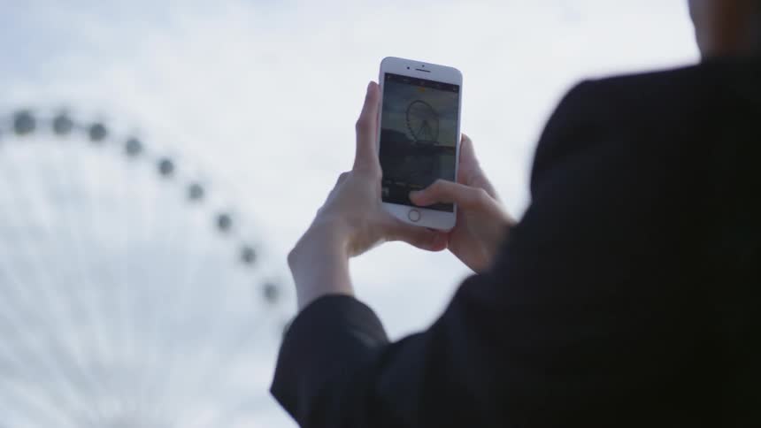 A person is taking a picture of a ferris wheel