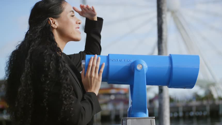 A woman looking through the binoculars at the amusement park