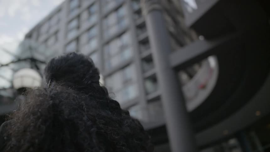 A woman looks around the city on a cloudy day
