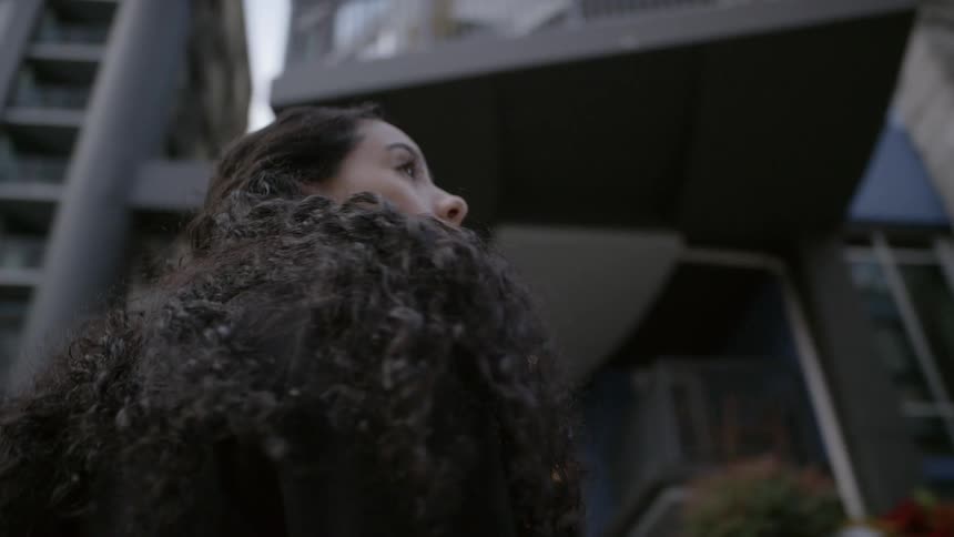 A woman is walking around in a downtown city