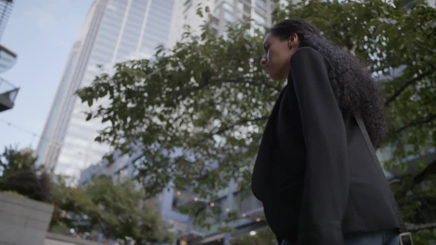 A woman with suit walks in the city