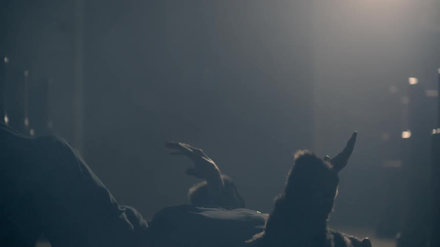Person laying on the floor swaying their hands back and forth in the air