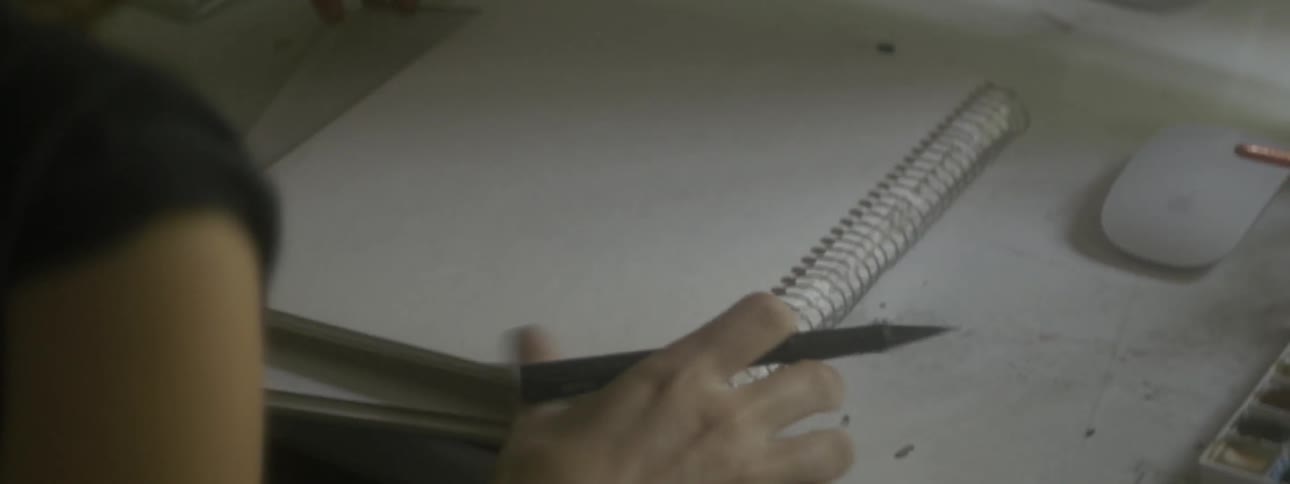 A woman starting to draw on an art book at a desk