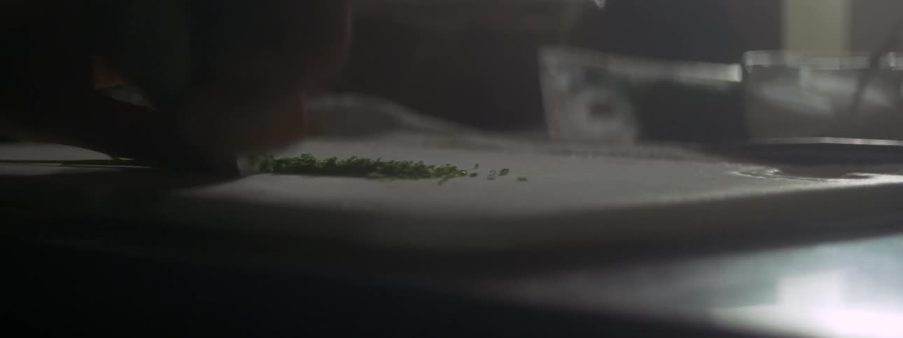 Someone chopping a vegetable with a knife