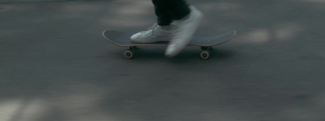 A person skateboarding down the road
