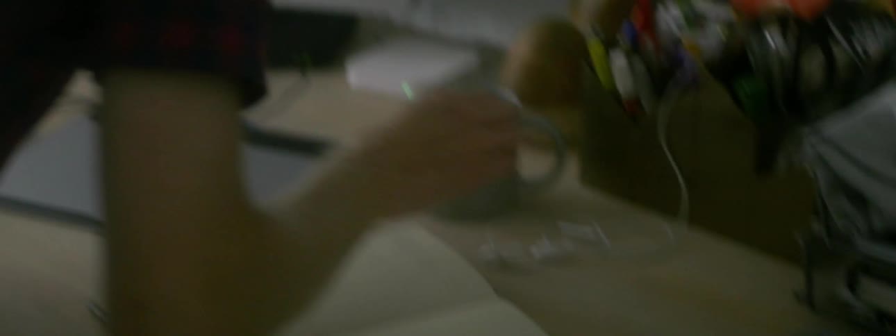 A person setting down their books and looking in a notebook