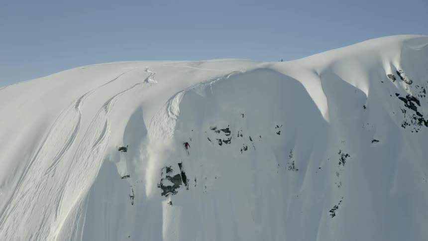 A peron skis alone down a tall steep mountainside