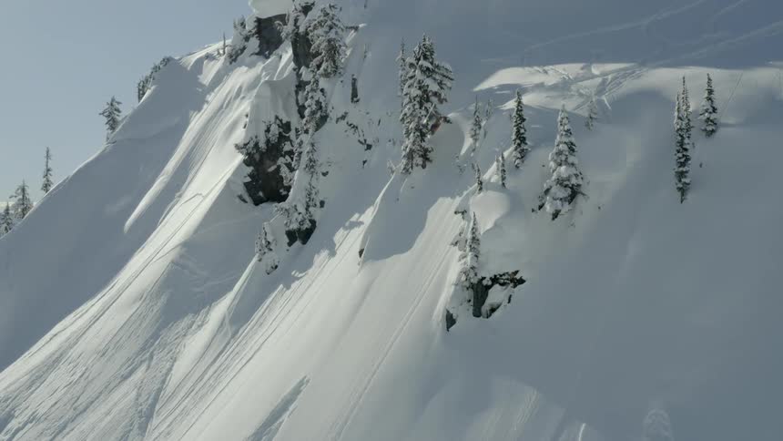 A man doing an extreme jump with a snowboard on the snowy hill