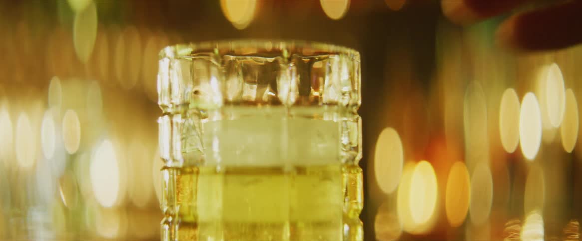 A hand putting a glass of beer