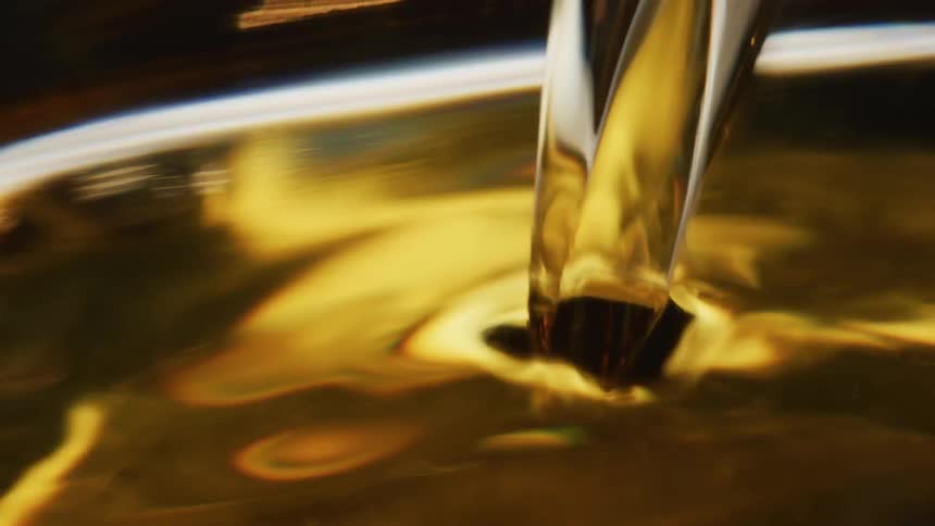 An amber liquid is being poured into a container