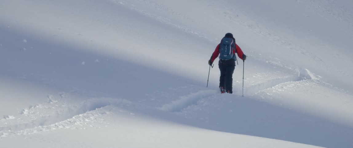 A man doing a hiking on the snowy mountain