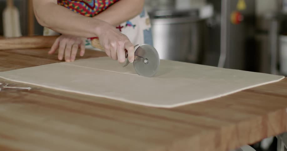 A woman cuts a pastry