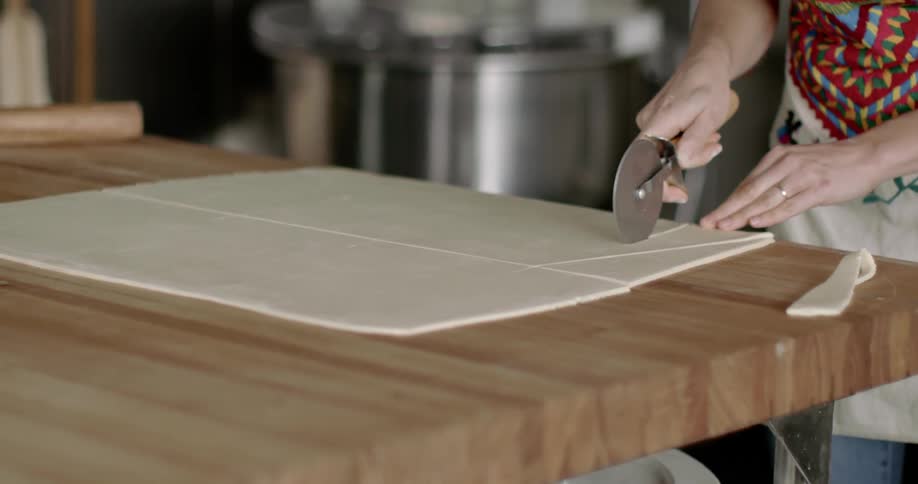 Woman cutting dough into triangular shape