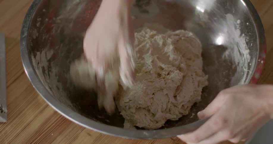 A person is mixing dough in a bowl