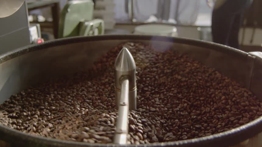Stirring coffee beans in a large container