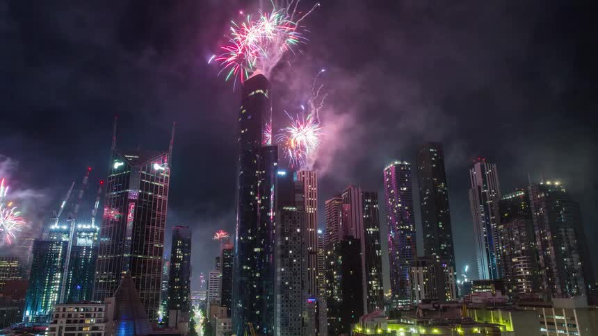 A time lapse of a city skyline from day to night with fireworks