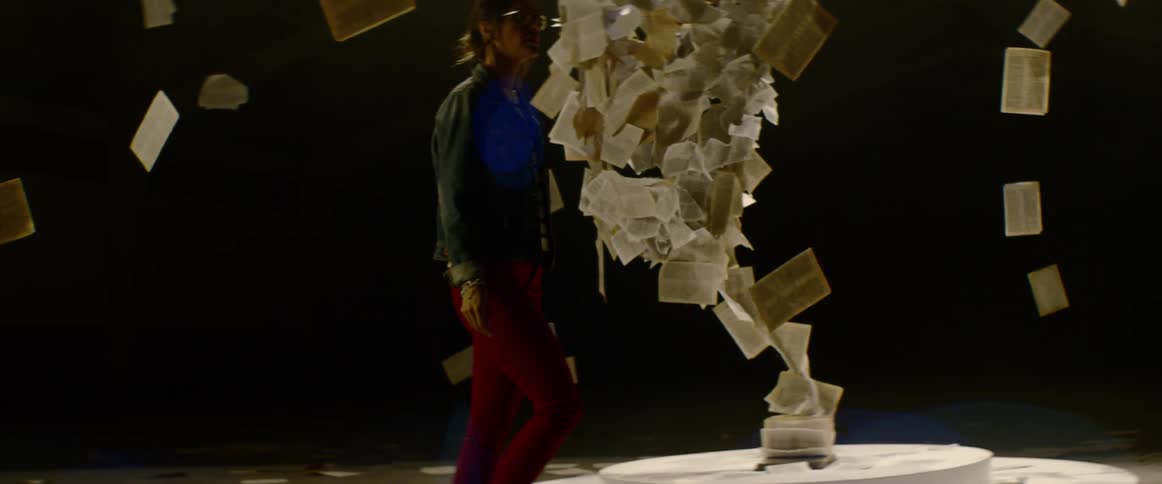 A woman examines text suspended in the air as part of an installation