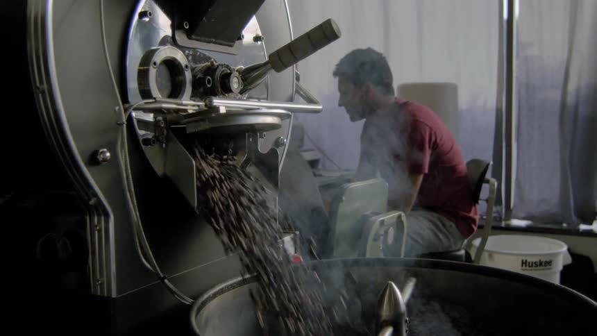 A man grinding coffee at the factory