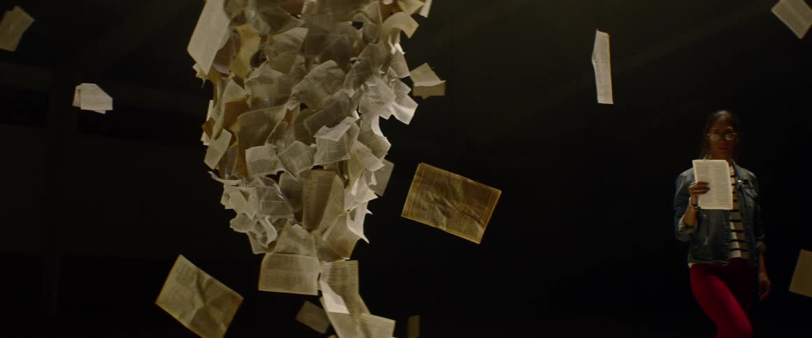 A woman examines text suspended in the air as part of an installation