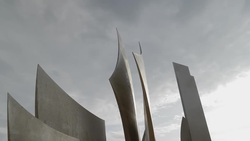 Curved walls and concrete sails of decorative architecture against a cloudy sky