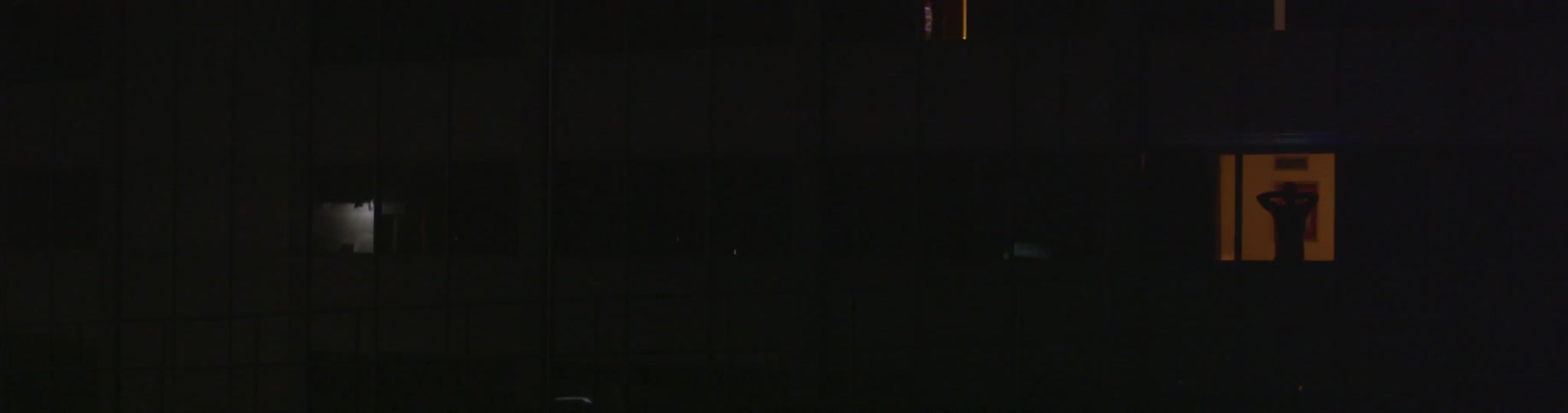 Dark view of the side of a building with no external lighting at night